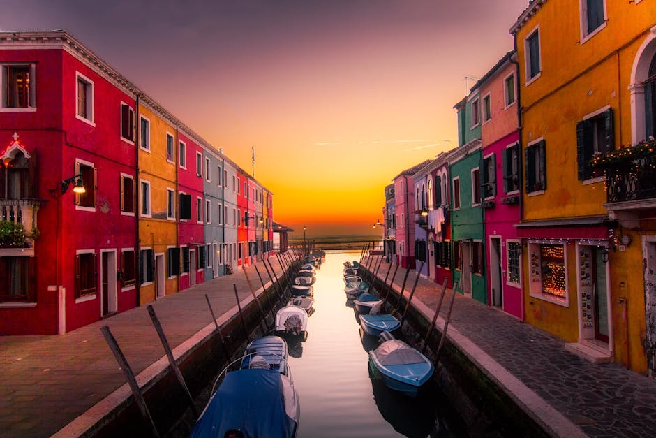 Vibrant facades along Burano's canal with boats at serene sunset